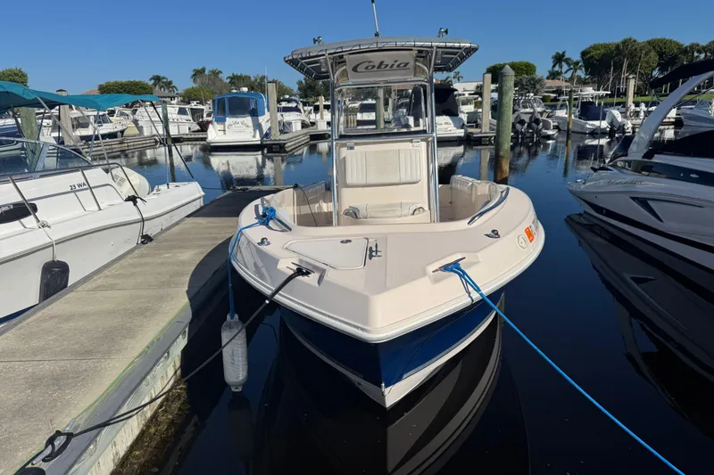 Slide: The Image of 2007 Cobia 237 Center Console boat docked at marina, surrounded by other vessels. - 4