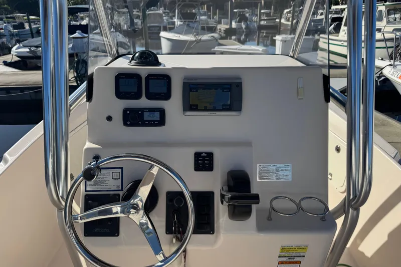 Slide: The Image of 2007 Cobia 237 Center Console boat dashboard with steering wheel and navigation controls. - 5