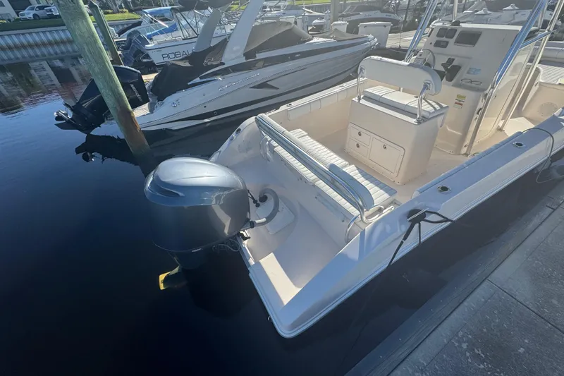 Slide: The Image of 2007 Cobia 237 Center Console boat docked, featuring spacious seating and modern controls. - 9