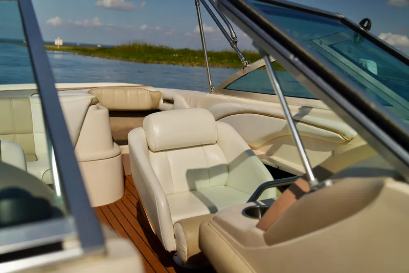Slide: The Image of 1995 Sea Ray 200 Bow Rider interior with white leather seats on a sunny day. - 10
