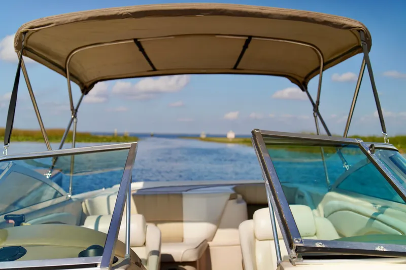 Slide: The Image of 1995 Sea Ray 200 Bow Rider on a sunny day, cruising on a calm waterway. - 11