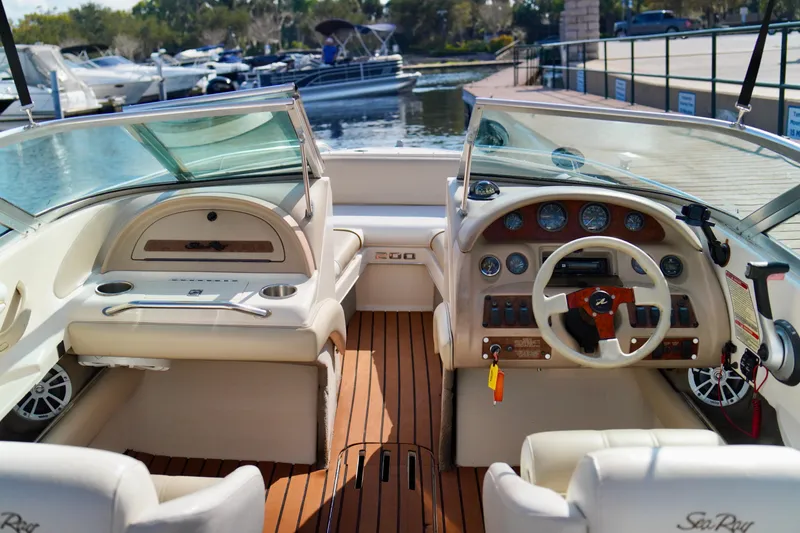Slide: The Image of 1995 Sea Ray 200 Bow Rider interior with steering wheel and dashboard, docked at marina. - 12