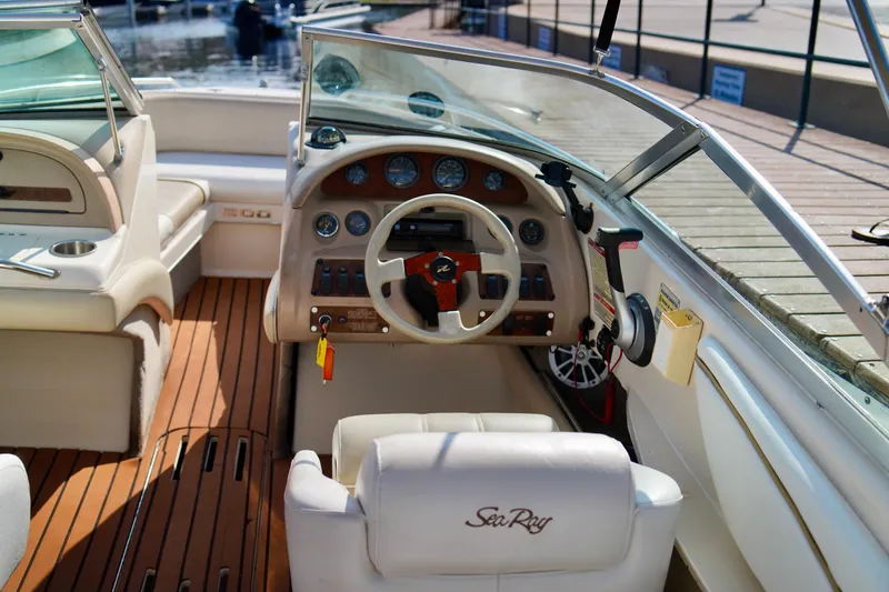 Slide: The Image of 1995 Sea Ray 200 Bow Rider boat interior with steering wheel and dashboard controls. - 13