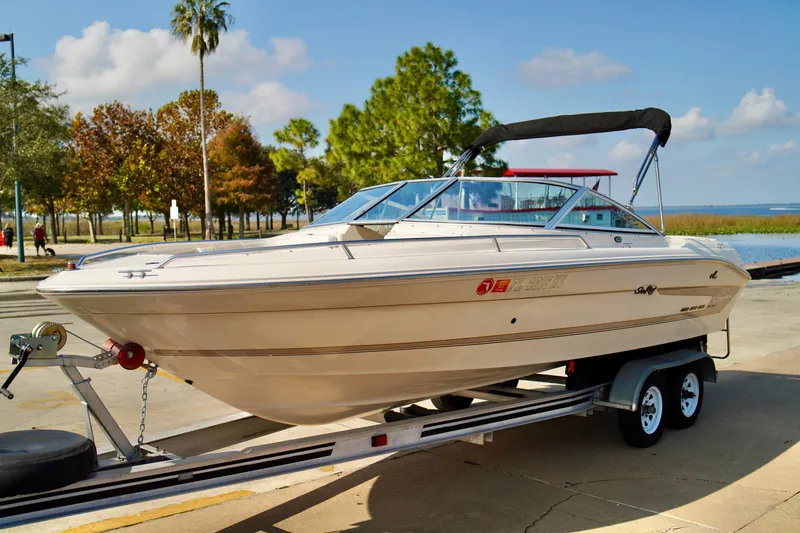 Slide: The Image of 1995 Sea Ray 200 Bow Rider on trailer, parked near scenic waterfront. - 3