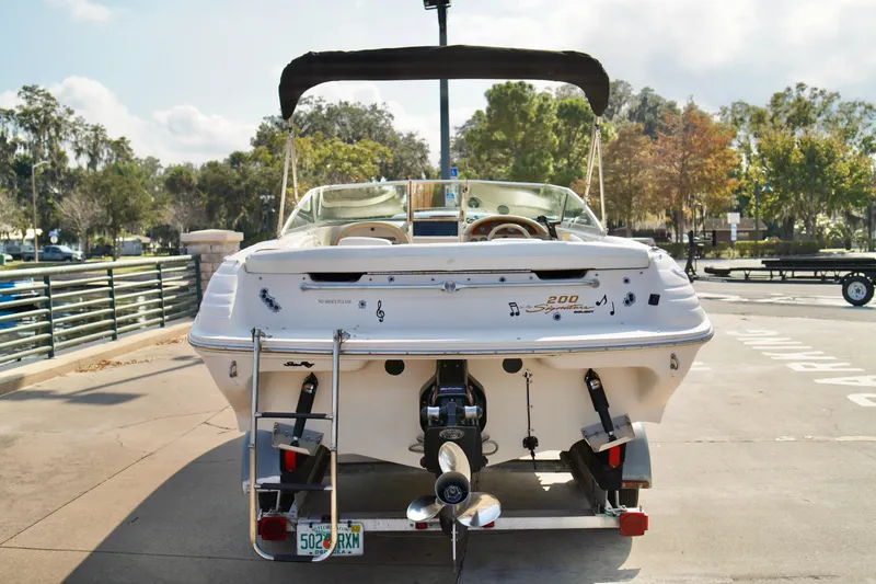 Slide: The Image of 1995 Sea Ray 200 Bow Rider boat on trailer, parked outdoors with scenic background. - 30