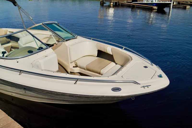 Slide: The Image of 1995 Sea Ray 200 Bow Rider boat docked on calm water. - 5