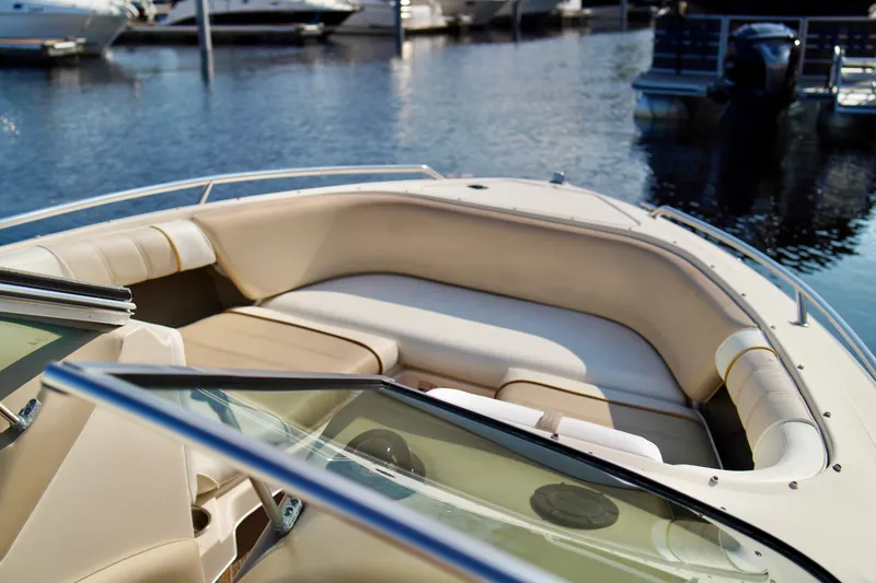 Slide: The Image of 1995 Sea Ray 200 Bow Rider boat interior with beige seating, docked at marina. - 6