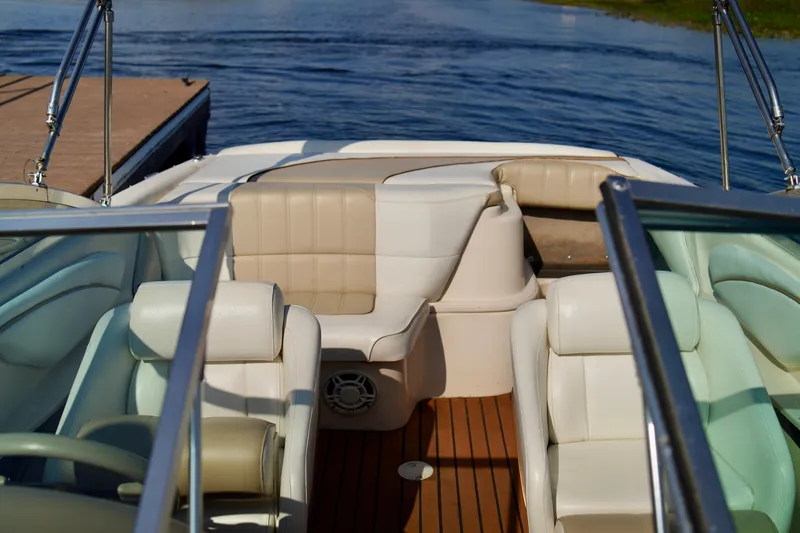 Slide: The Image of Interior of a 1995 Sea Ray 200 Bow Rider boat with beige seating and wooden flooring. - 9