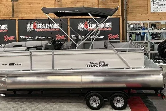 The Image of 2026 Sun Tracker Party Barge 22 RF DLX pontoon boat on display indoors. - 1