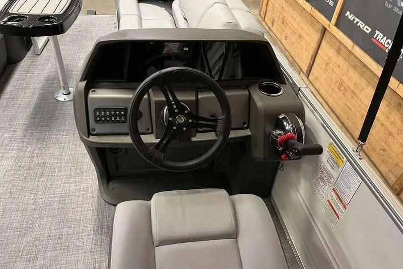 Slide: The Image of 2026 Sun Tracker Party Barge 22 RF DLX steering console with modern controls and seating. - 5