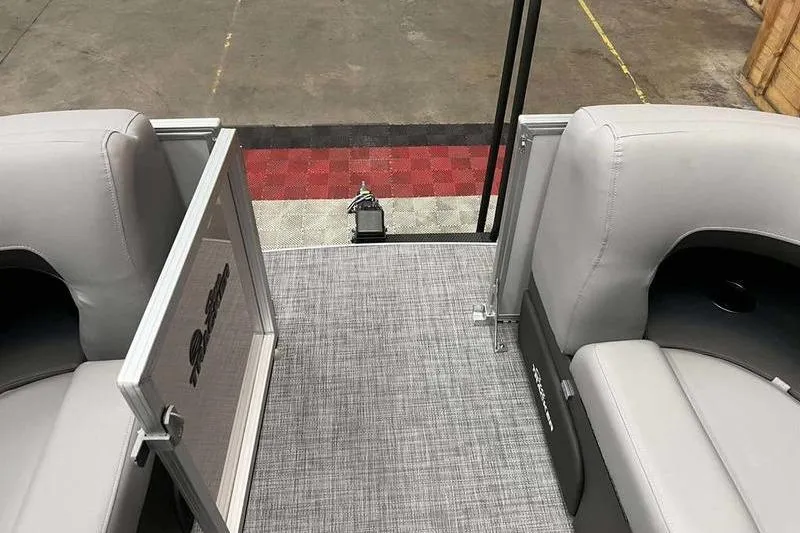 Slide: The Image of 2026 Sun Tracker Party Barge 22 RF DLX interior with gray seating and open gate. - 8