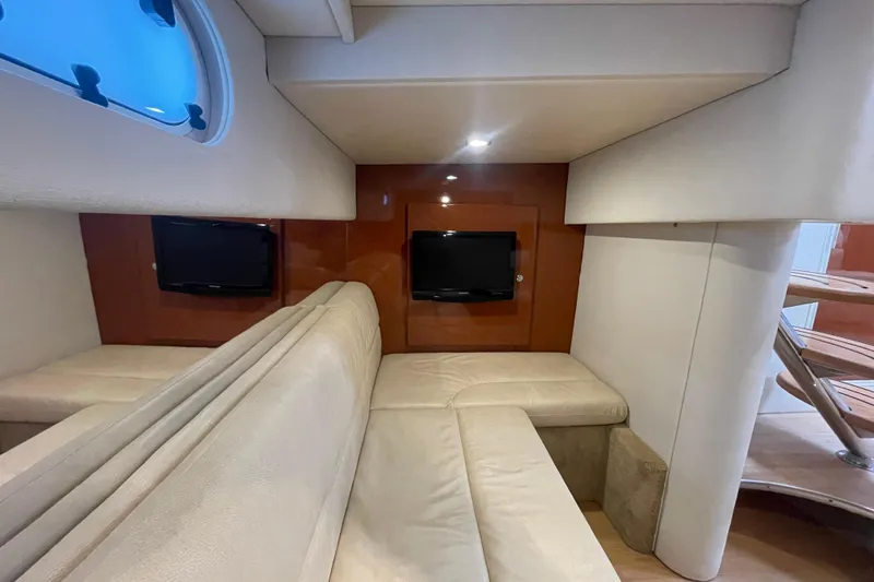 Slide: The Image of 2011 Formula 34 Performance Cruiser interior with beige seating and dual TVs. - 32