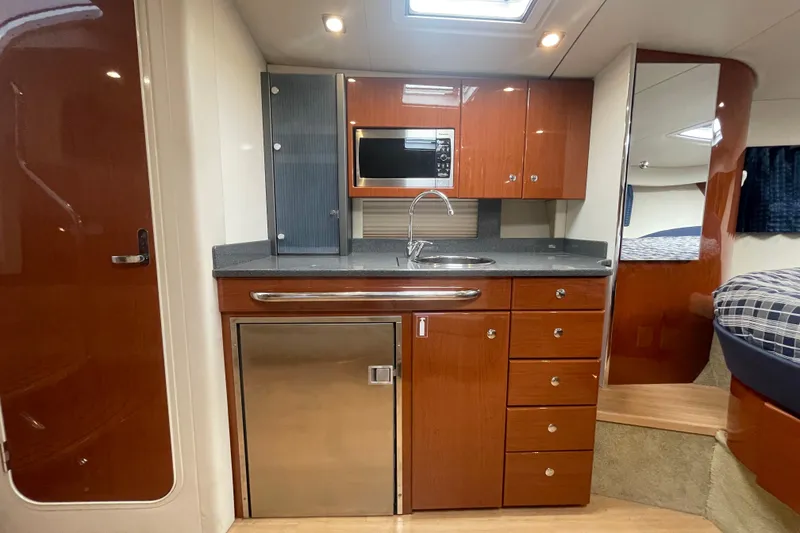 Slide: The Image of Interior of 2011 Formula 34 Performance Cruiser with kitchenette, wood cabinets, and stainless steel appliances. - 36