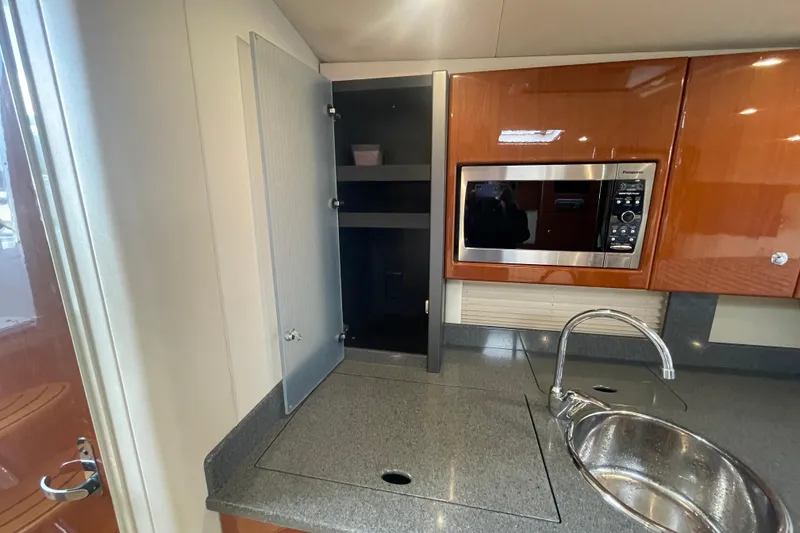 Slide: The Image of 2011 Formula 34 Performance Cruiser kitchen with microwave, sink, and storage cabinet. - 37