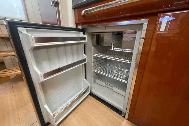 Slide: The Image of Open refrigerator inside 2011 Formula 34 Performance Cruiser, showcasing interior shelves and door storage. - 38