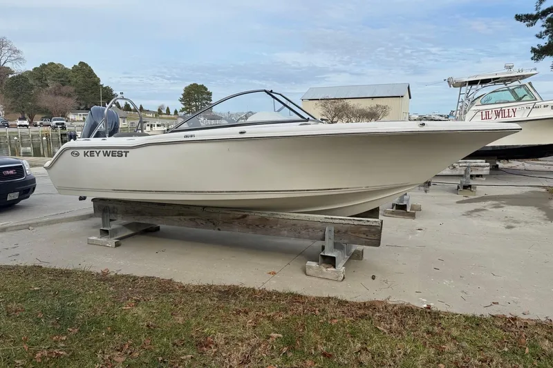 The Image of 2026 Key West 203 DFS boat on trailer, parked outdoors on gravel. - 0