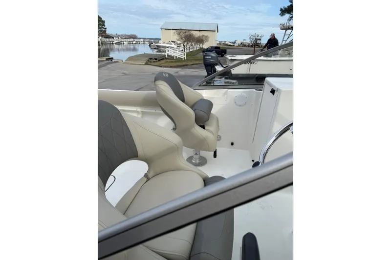 Slide: The Image of 2026 Key West 203 DFS boat interior with beige seating and steering console. - 6