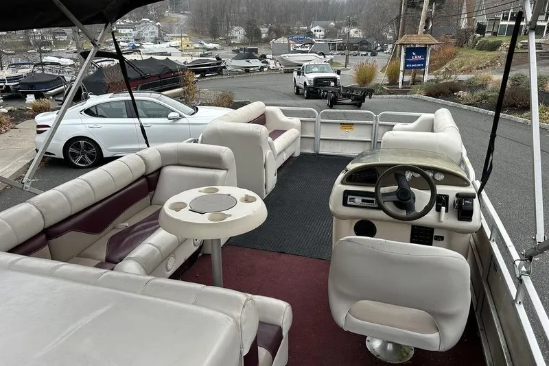 Slide: The Image of Interior of a 2003 Sweetwater 2221 SC pontoon boat with seating and steering wheel. - 2