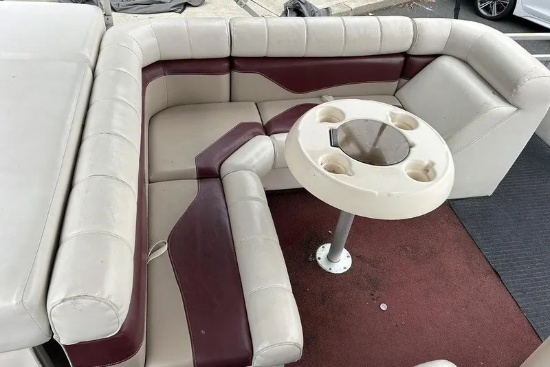 Slide: The Image of 2003 Sweetwater 2221 SC boat interior with cushioned seating and round table. - 6