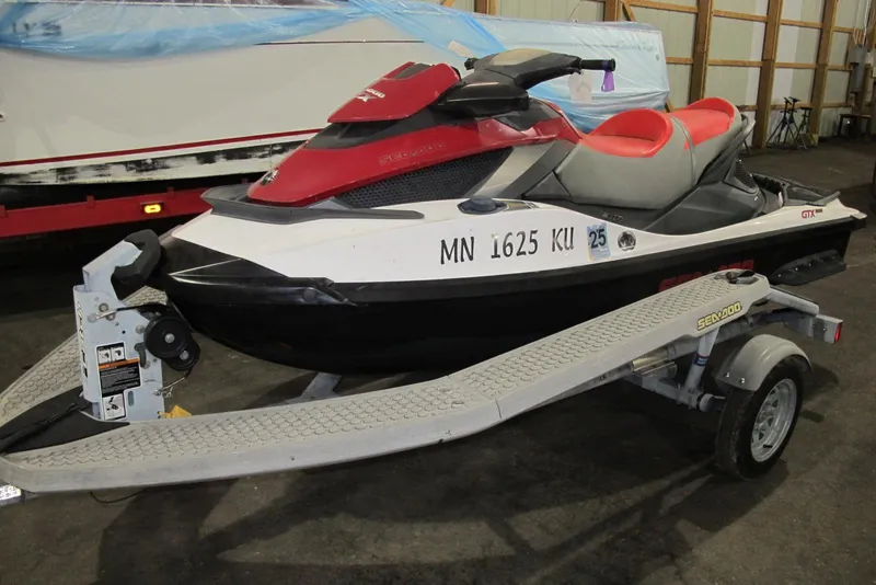 The Image of 2011 Sea-Doo GTX 155 jet ski on trailer in a storage facility. - 0