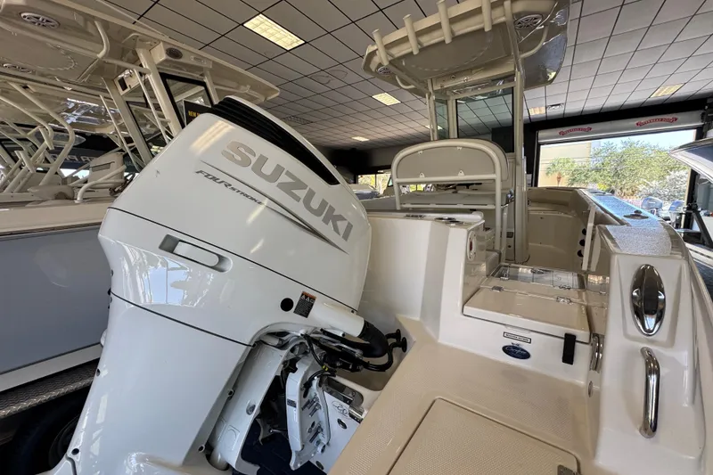 Slide: The Image of 2026 Sailfish 232 CC boat with Suzuki outboard motor in showroom. - 2