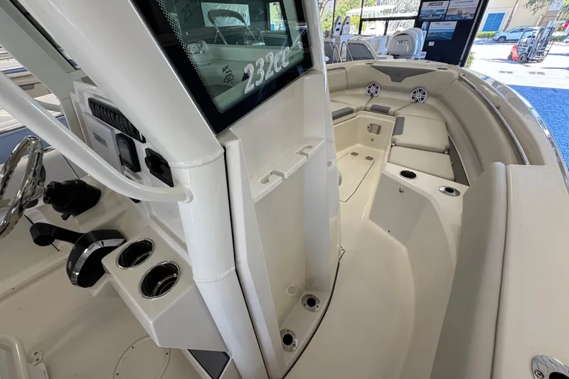 Slide: The Image of 2026 Sailfish 232 CC boat interior with seating, cup holders, and steering console. - 7