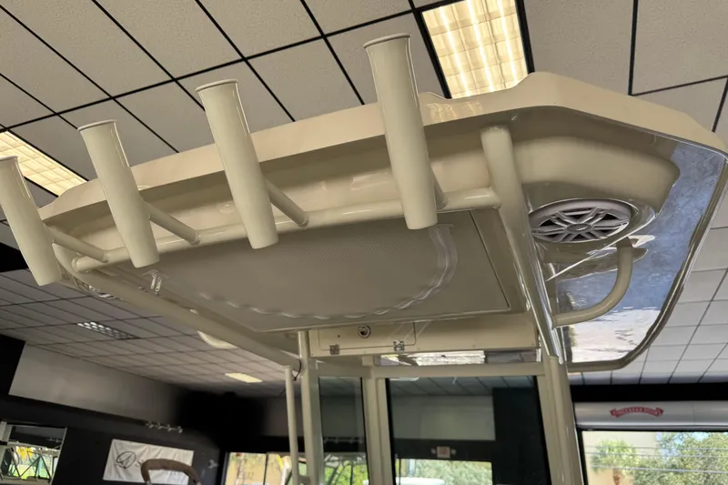 Slide: The Image of 2026 Sailfish 232 CC boat's T-top with rod holders and speaker in showroom. - 8