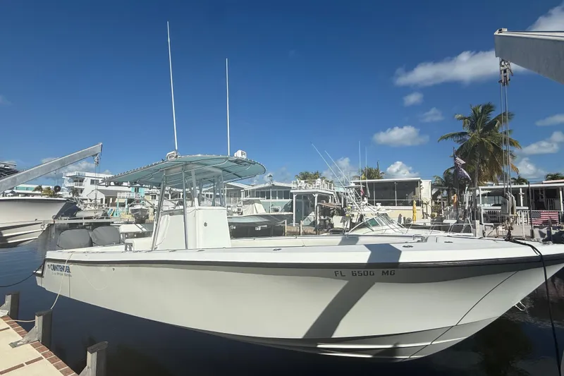 Slide: The Image of 2003 Contender 27 Open boat on calm blue water under clear sky. - 0