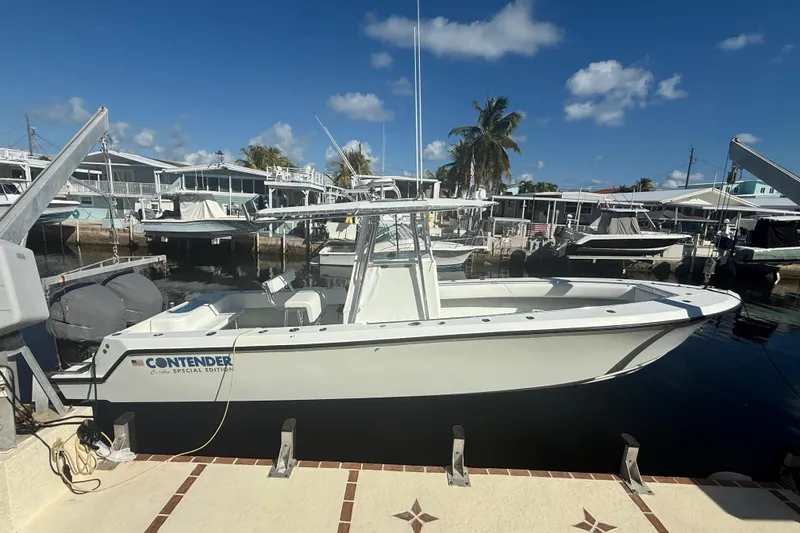 Slide: The Image of 2003 Contender 27 Open boat cruising on calm waters under a clear blue sky. - 1