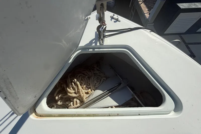 Slide: The Image of 2003 Contender 27 Open boat cockpit with Garmin navigation system, docked by waterfront homes. - 13