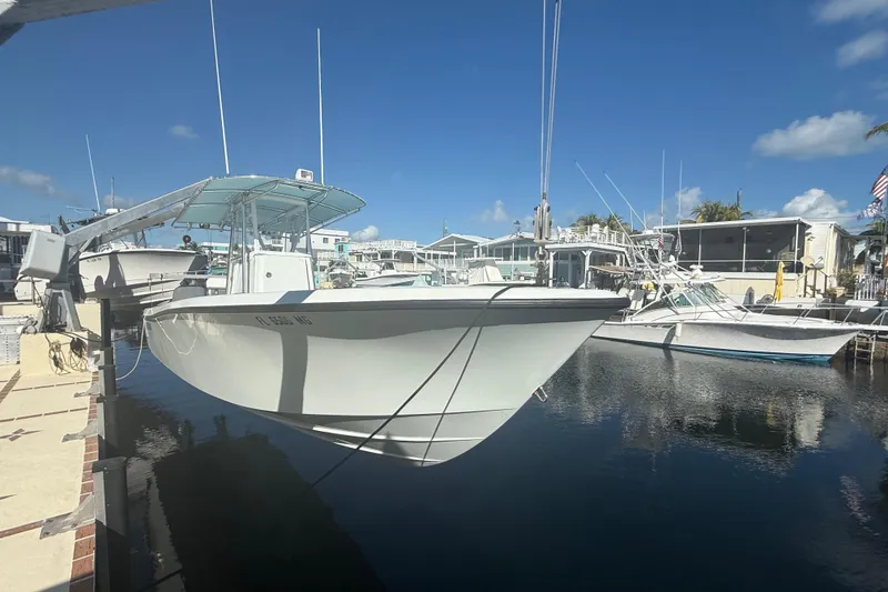 Slide: The Image of 2003 Contender 27 Open boat on calm blue water, clear sky background. - 2