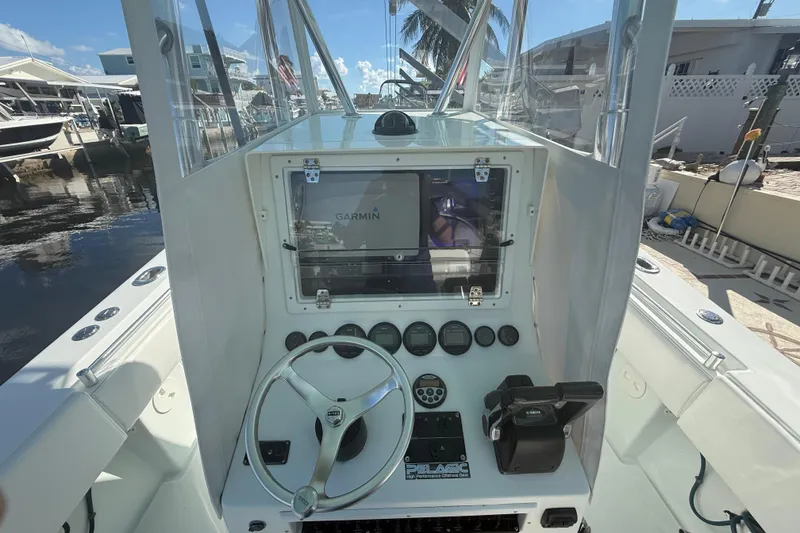 Slide: The Image of 2003 Contender 27 Open boat docked in a sunny marina, featuring a sleek design. - 20