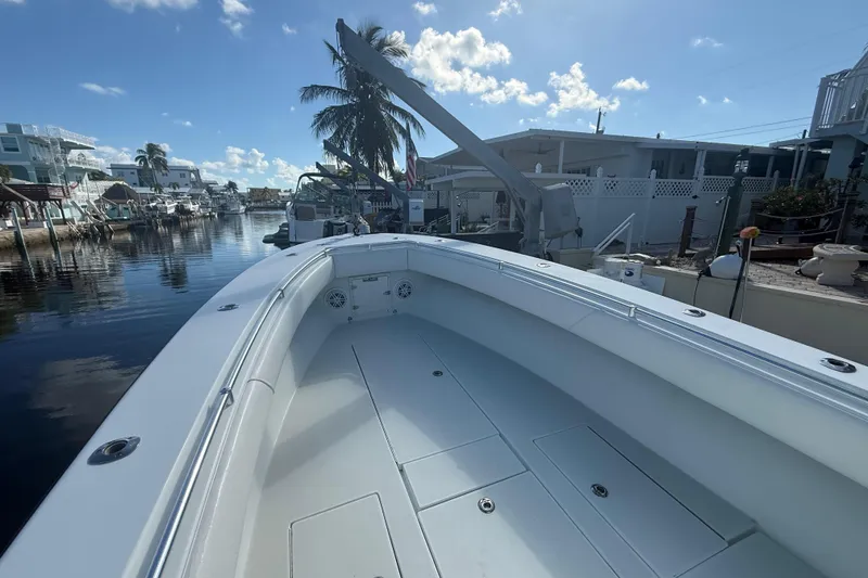 Slide: The Image of 2003 Contender 27 Open boat docked at marina, featuring spacious seating and calm waters. - 24