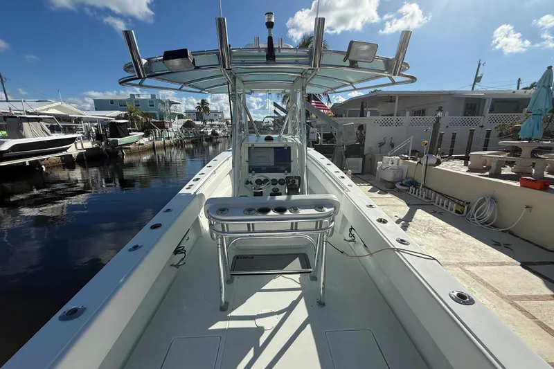 Slide: The Image of 2003 Contender 27 Open boat docked in a sunny marina, showcasing spacious deck layout. - 27