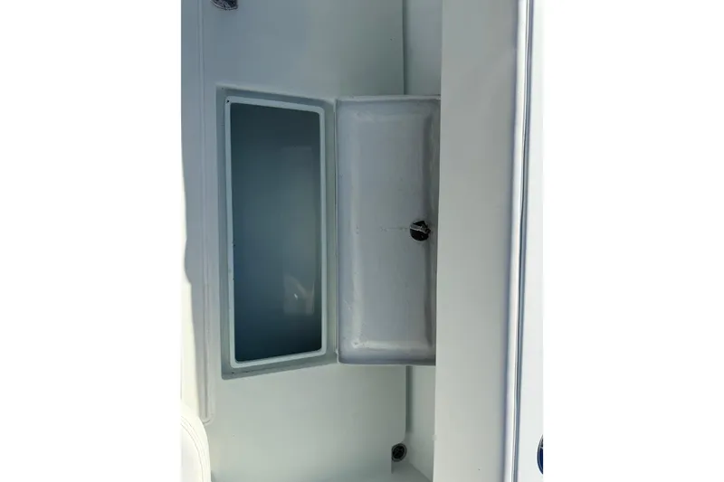Slide: The Image of 2003 Contender 27 Open boat interior with open storage compartment, docked at marina. - 28