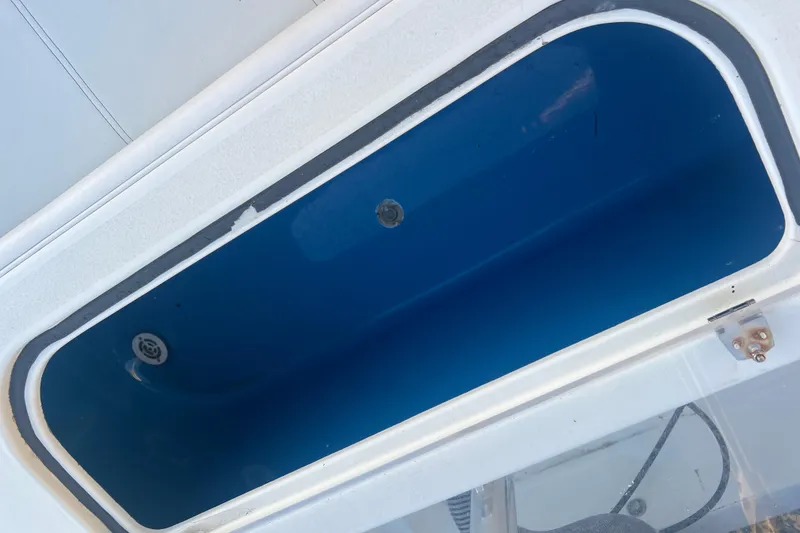 Slide: The Image of Open storage compartment on 2003 Contender 27 Open boat, featuring a blue interior. - 58