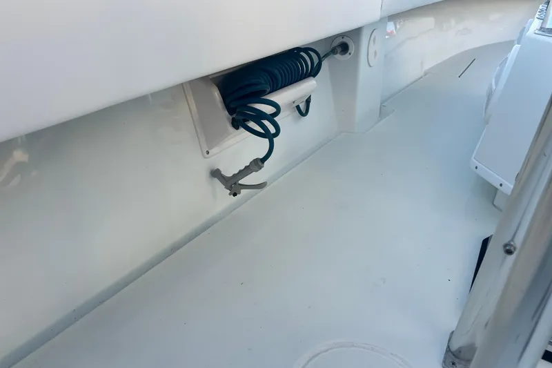 Slide: The Image of 2003 Contender 27 Open boat interior with coiled hose and clean white deck. - 63