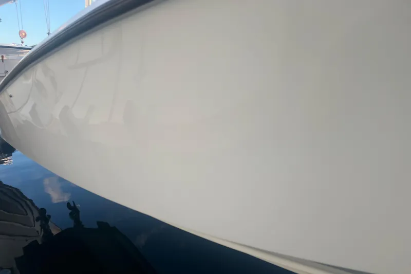 Slide: The Image of 2003 Contender 27 Open boat hull reflecting on water, showcasing sleek design. - 66
