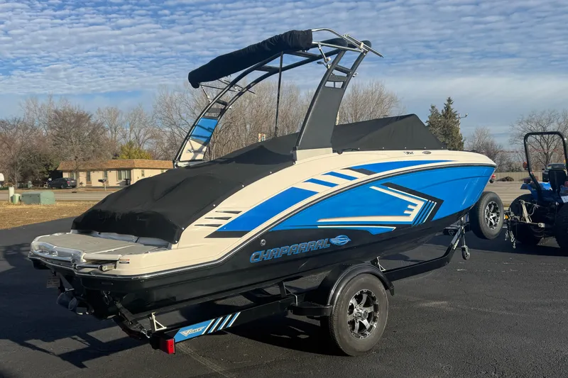 Slide: The Image of 2018 Chaparral Vortex 203 VRX boat with blue accents on a trailer, parked outdoors. - 6
