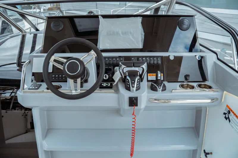 Slide: The Image of 2025 Jeanneau Leader 10.5 WA Series 2 helm with modern controls and steering wheel. - 20