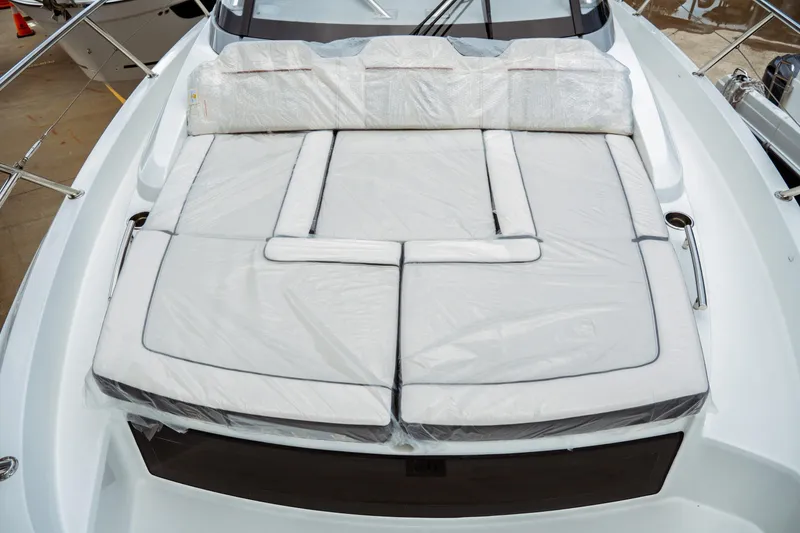 Slide: The Image of 2025 Jeanneau Leader 10.5 WA Series 2 boat with cushioned deck, docked in marina. - 23