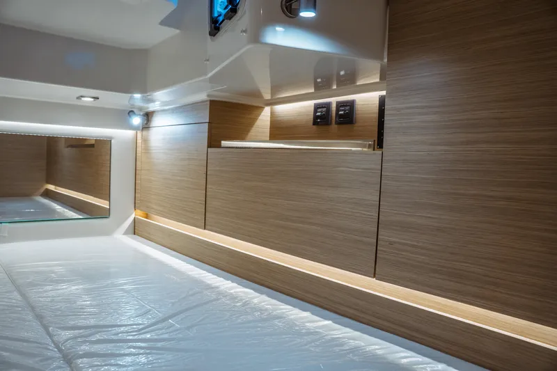 Slide: The Image of 2025 Jeanneau Leader 10.5 WA Series 2 cabin interior with modern wood paneling and lighting. - 38