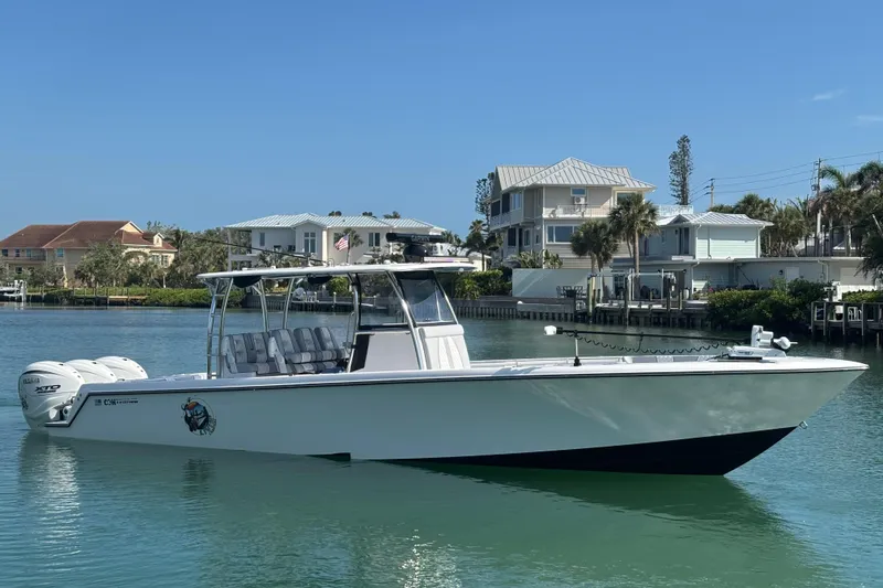 The Image of 2025 Contender 39 ST boat on calm water, with modern coastal homes in the background. - 0