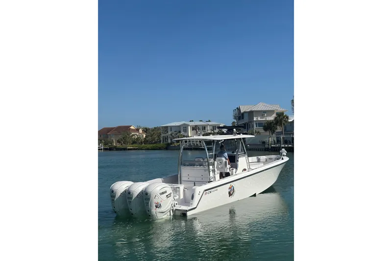 Slide: The Image of 2025 Contender 39 ST boat with triple Yamaha engines on calm water. - 1