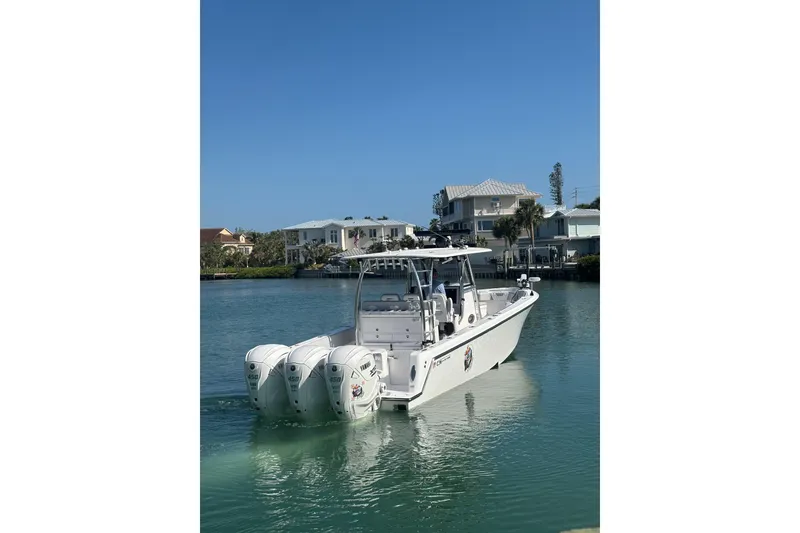 Slide: The Image of 2025 Contender 39 ST boat with triple engines on calm water. - 2