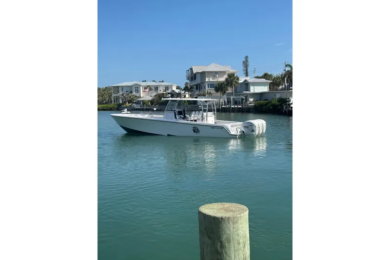 Slide: The Image of 2025 Contender 39 ST boat on calm water near waterfront homes. - 3