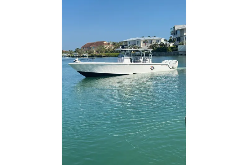 Slide: The Image of 2025 Contender 39 ST boat on calm water near waterfront homes. - 4