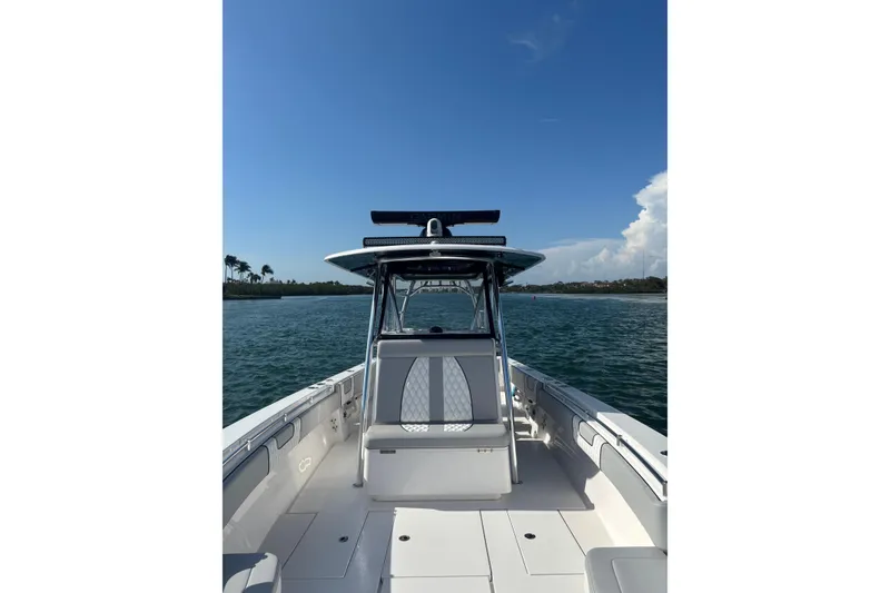 Slide: The Image of 2025 Contender 39 ST boat on water, clear sky, coastal view. - 6