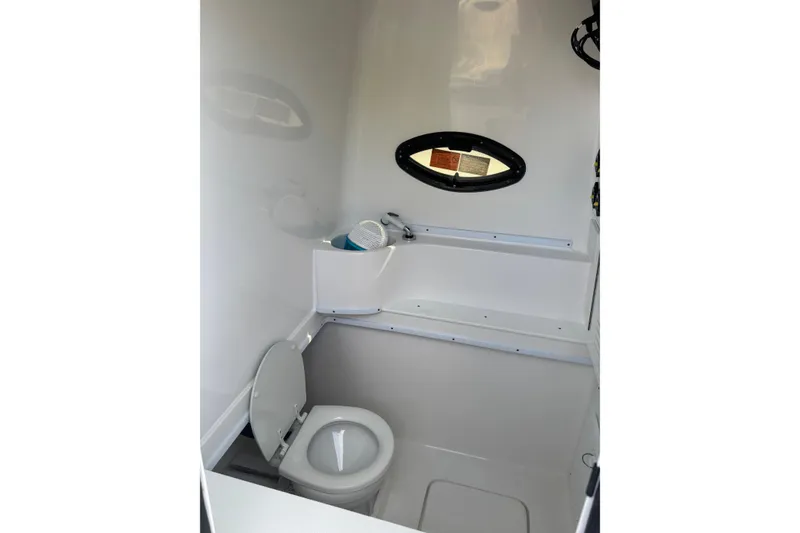 Slide: The Image of 2025 Contender 39 ST boat interior bathroom with toilet and small window. - 7