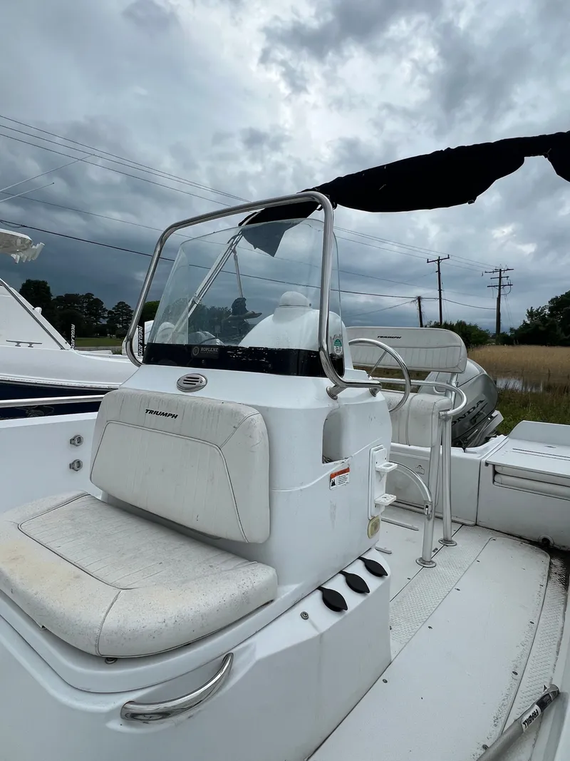 Slide: The Image of 2009 Triumph 190 Bay boat with steering console under cloudy sky. - 13